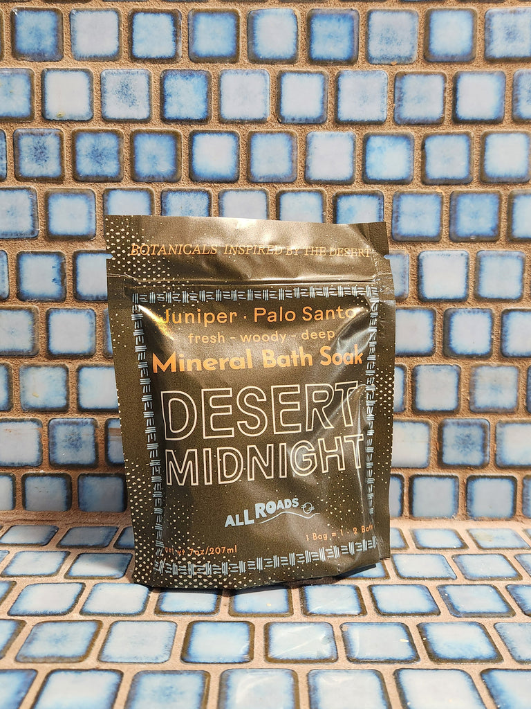 A green pouch of bath salts with juniper berry and palo santo essential oils. 