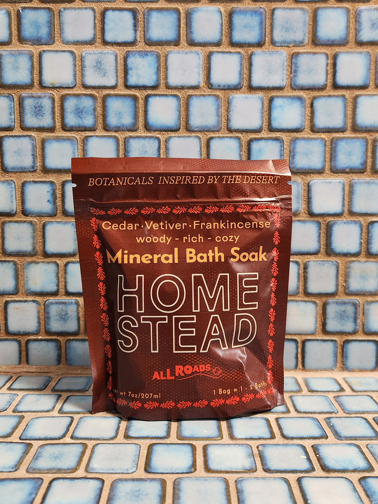 A burgundy pouch of bath salts scented with cedar, vetiver and frankincense essential oils.