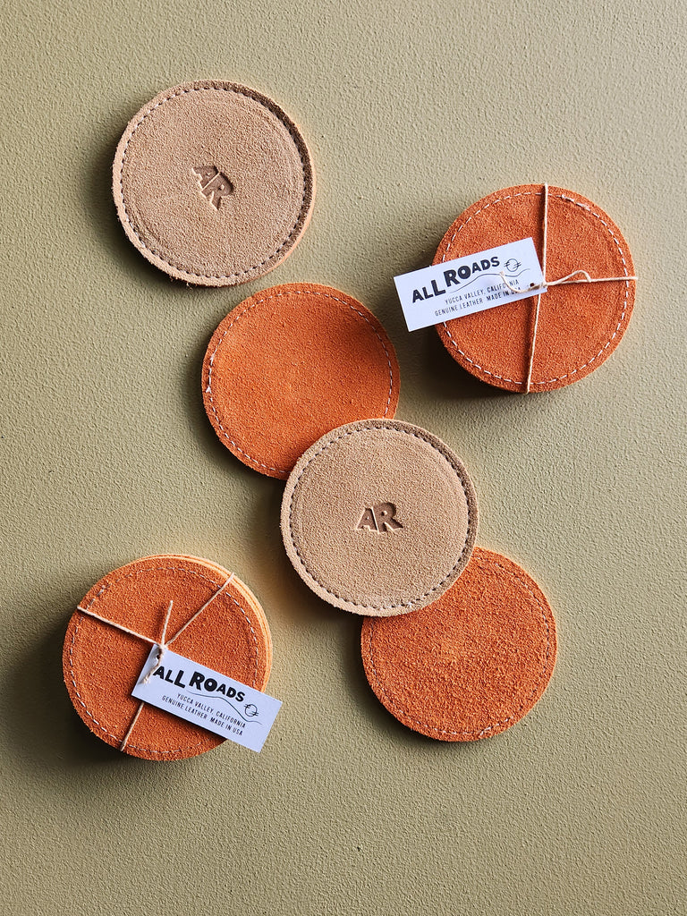 set of 4 suede coasters, 1 side orange and the other side tan branded with an AR.