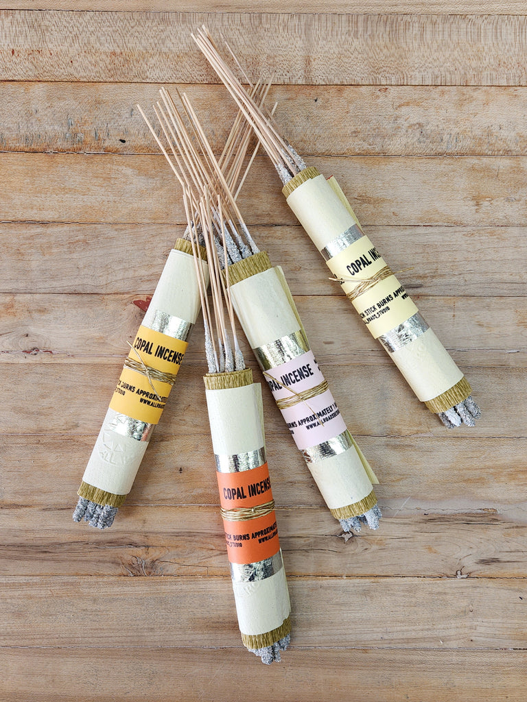Bundles of copal incense sticks, wrapped in metallic and colored papers.