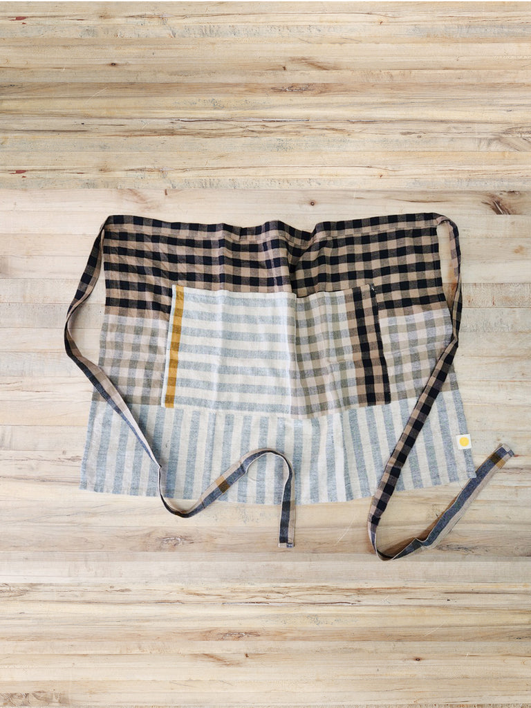 Black and cream plaid bistro apron with two front pockets.